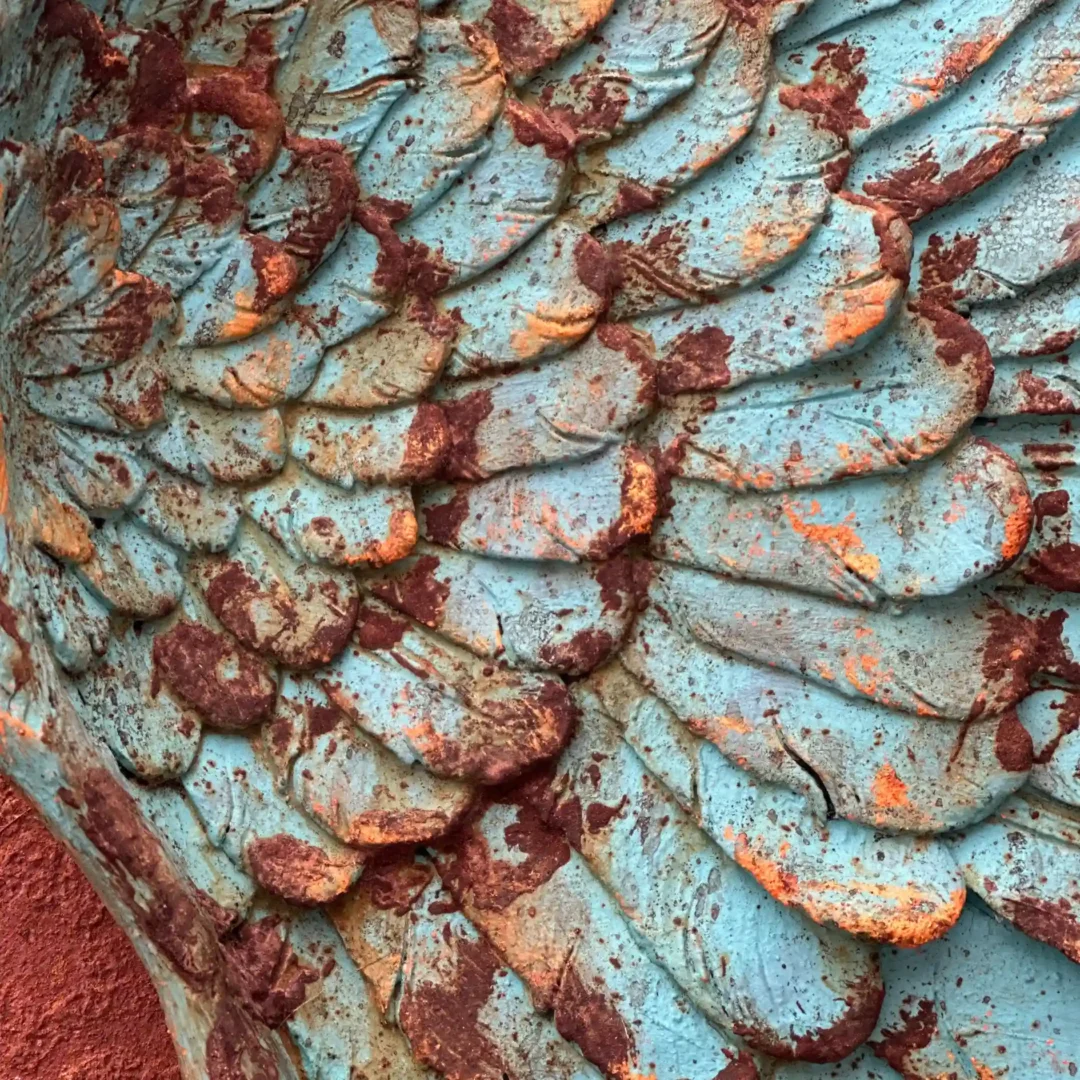Detalle en primer plano de las plumas talladas y textura oxidada de la pieza ArtSoul Wood "Renatum".