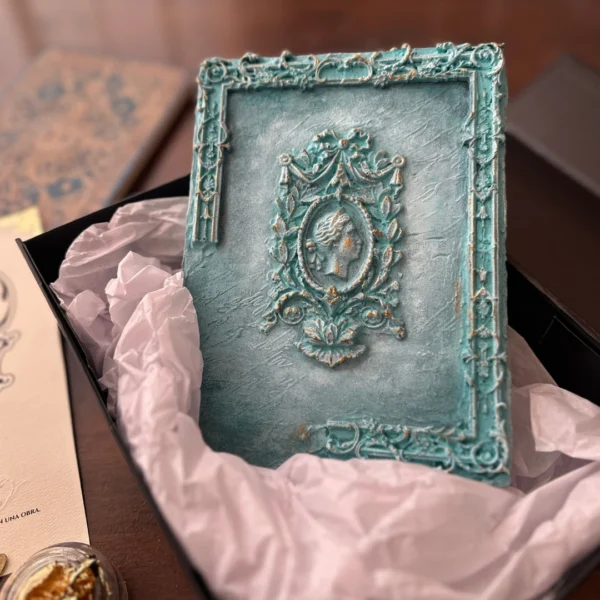 Pieza artesanal Anima Mater con camafeo en relieve y acabado turquesa envejecido presentada en su caja de entrega.