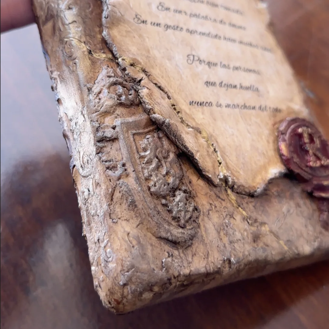 Detalle lateral de Anima Scripta con pergamino, escudo y grieta dorada