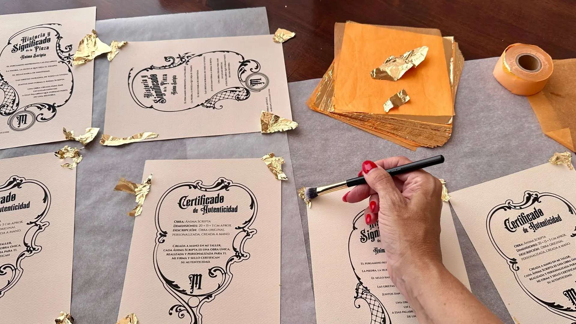 Marian trabajando a mano los detalles dorados de los certificados de Ánima Scripta